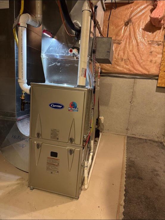 Carrier high-efficiency furnace installed by Mozee Gas in a London basement with new PVC venting and the Mozeegas sticker on the cabinet